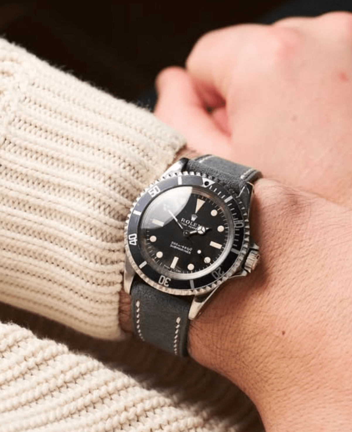 Person wearing a black wristwatch with a textured sleeve