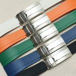 Four watch strap color options with silver-toned metal clasp, arranged diagonally on a light beige textured background. The straps are white, orange, green, blue, and black.
