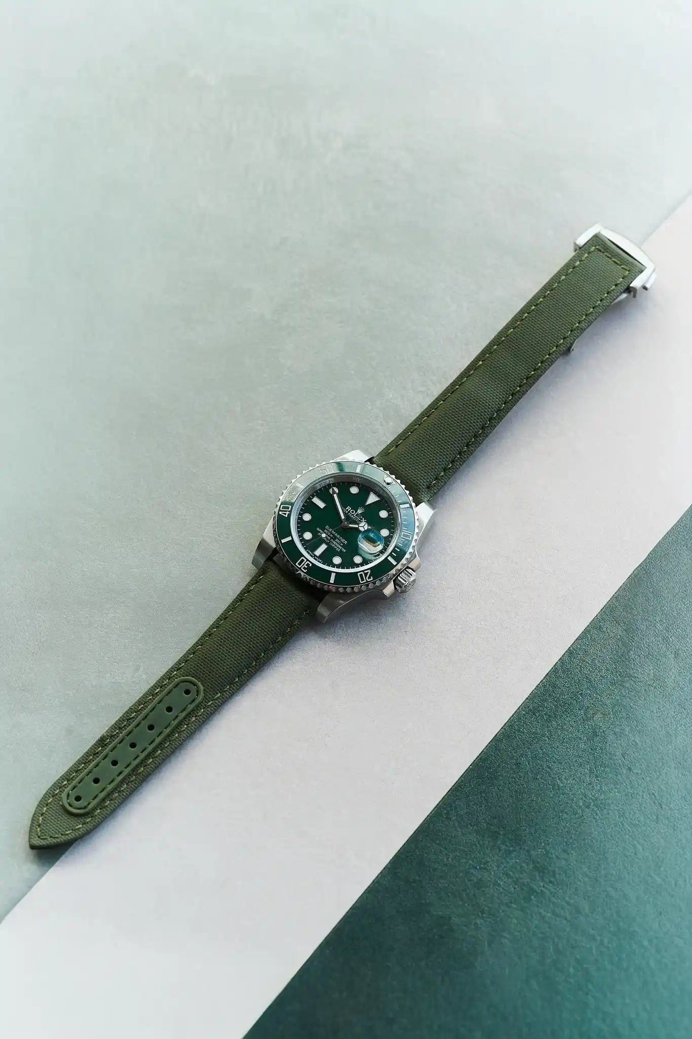 Watch with a green strap on a light gray and green background