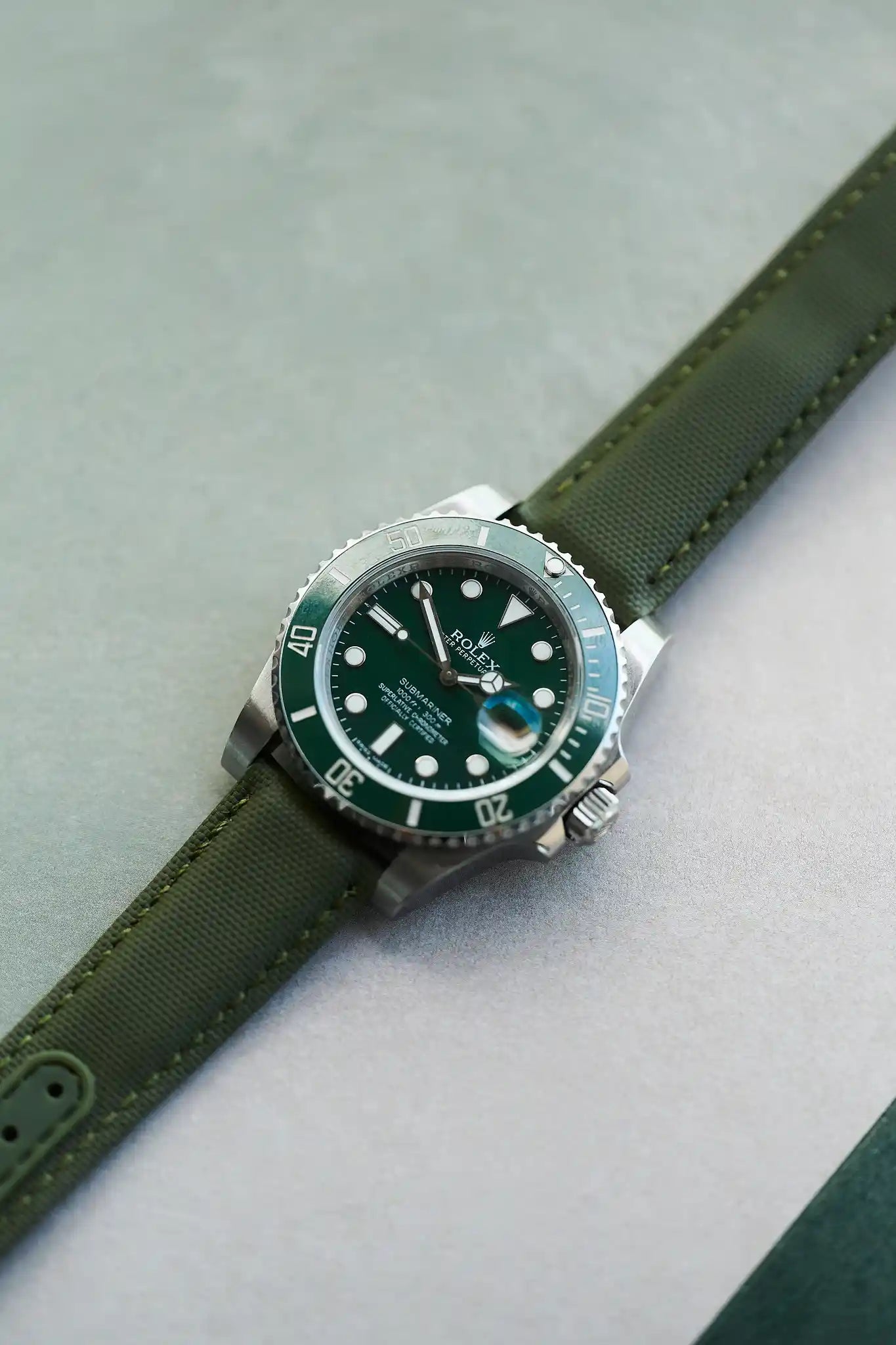 Watch with green strap and green dial on a light gray background