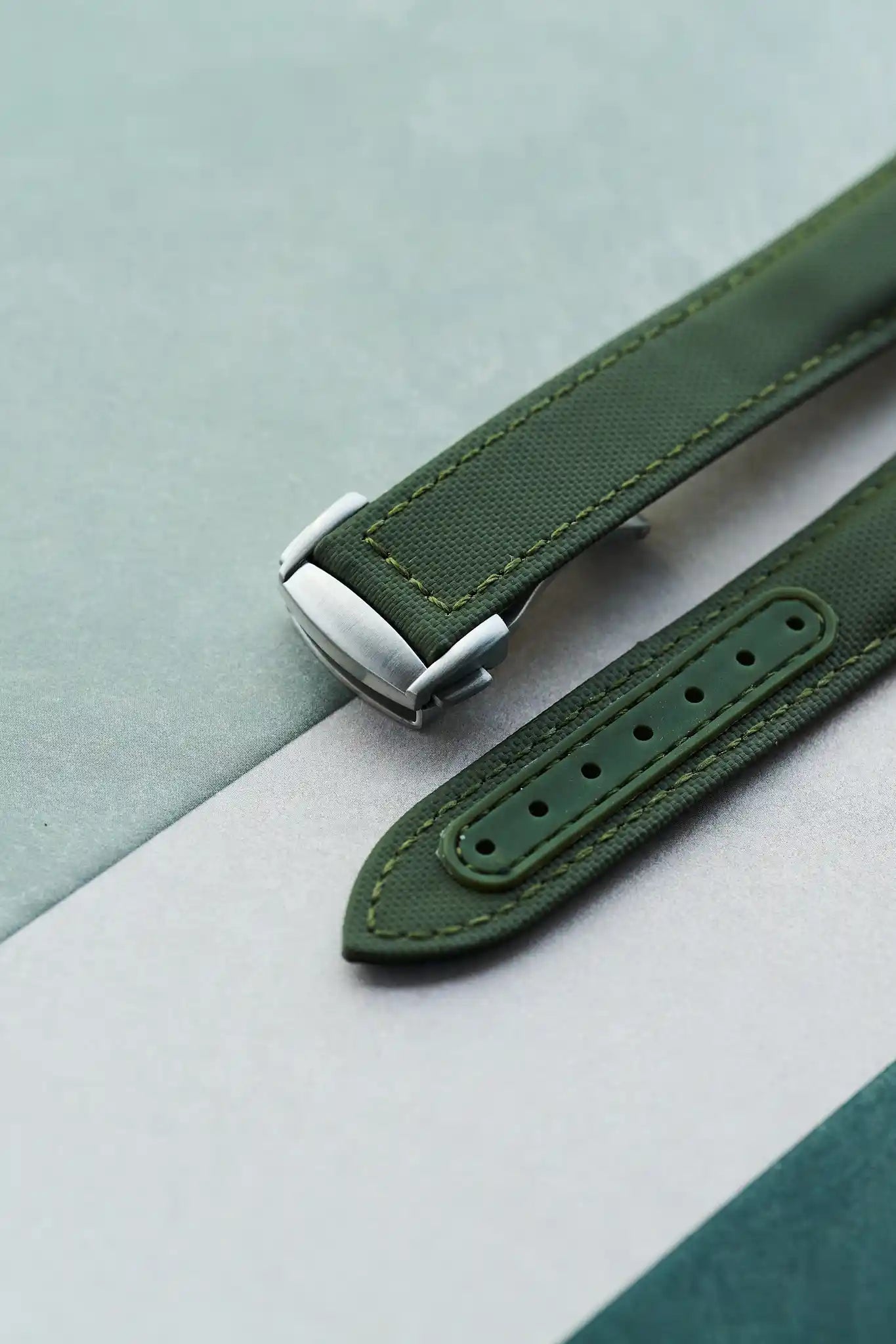 Green watch strap on a light gray background
