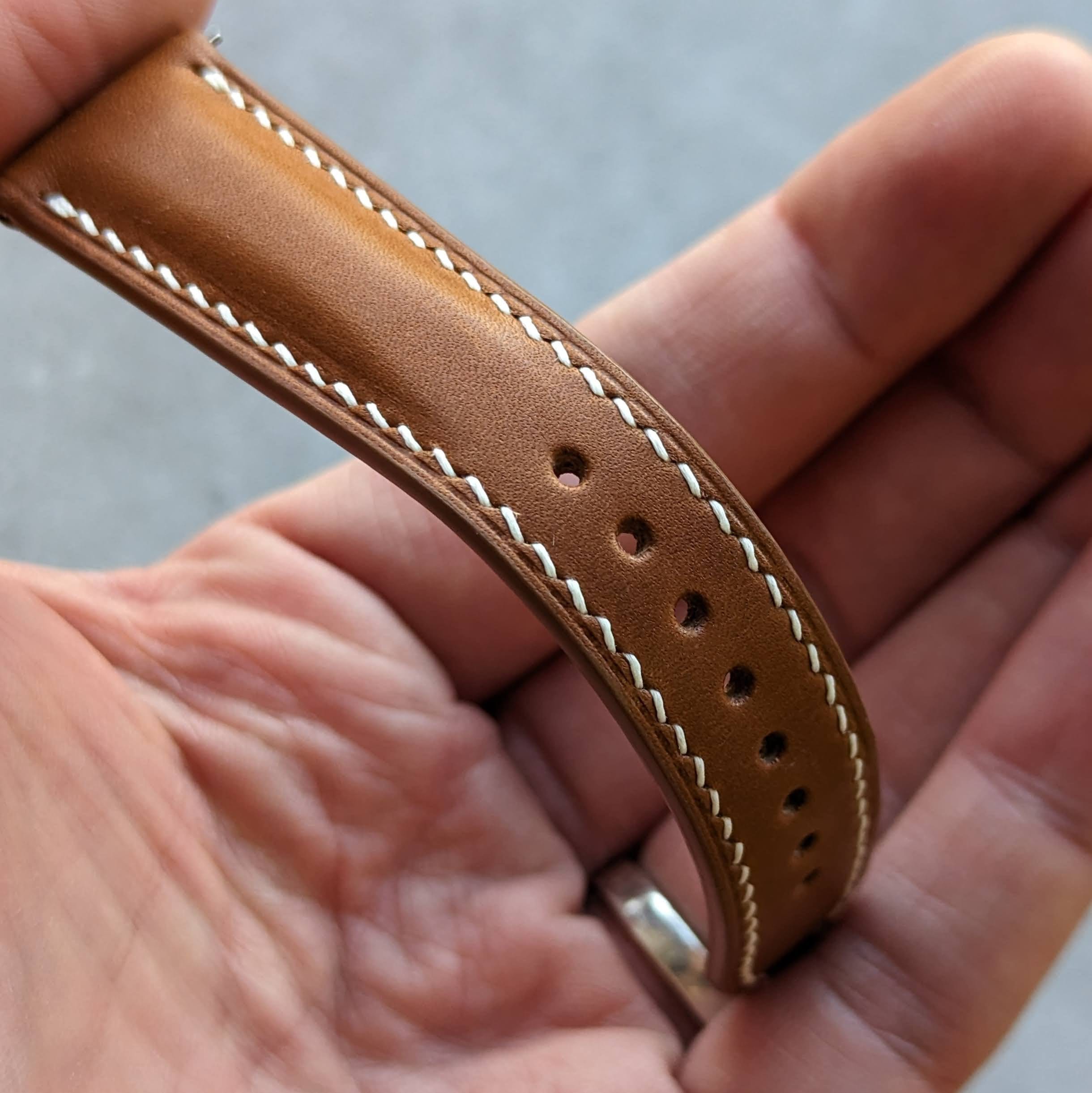 close up of tan brown watch strap with white stitching 